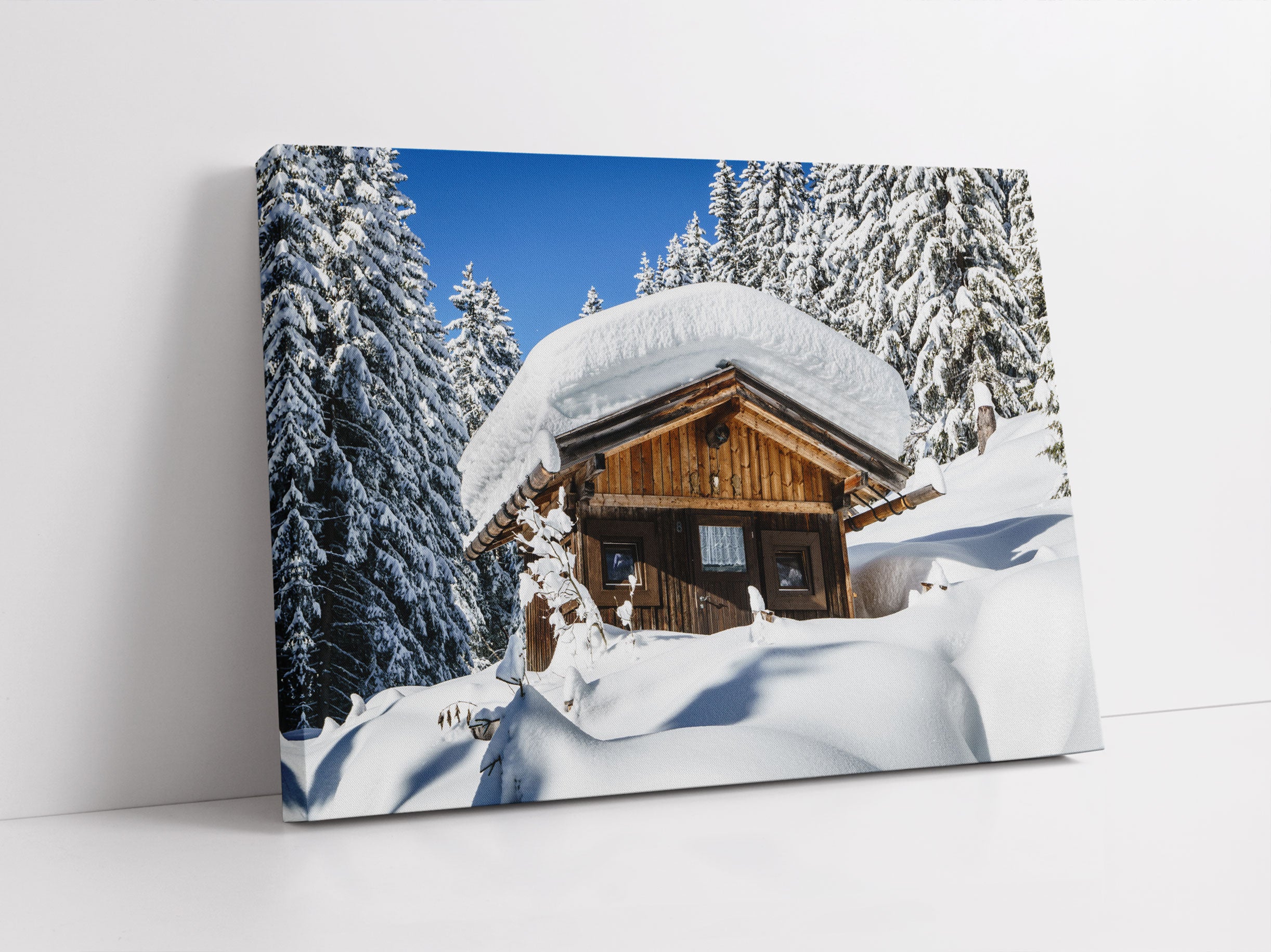 Verschneite Skihütte in Alpenwald Leinwandbild Studio