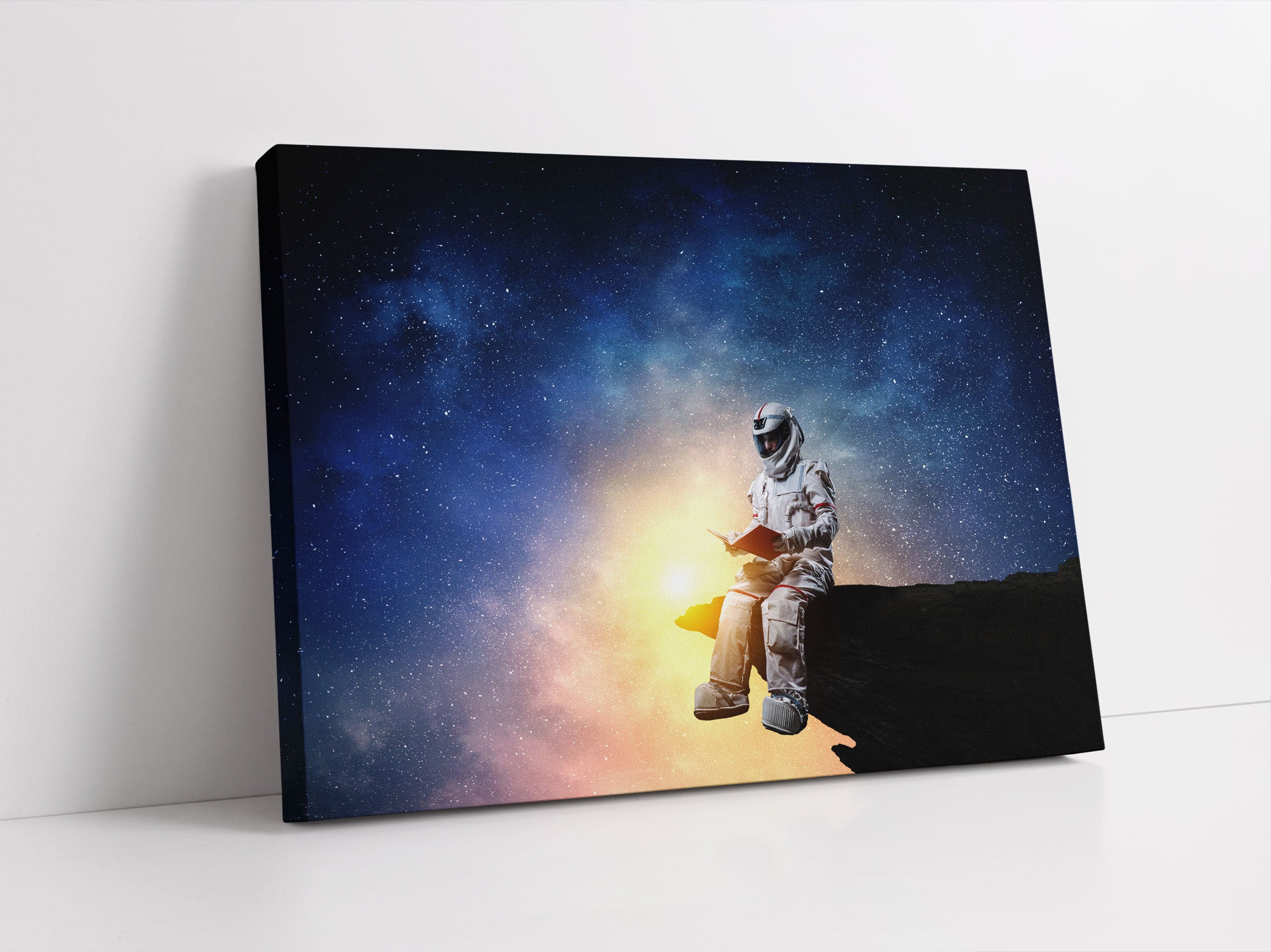 Lesender Astronaut auf Vorsprung vor Galaxie Leinwandbild Studio